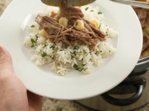Shredded beef barbacoa with creamy cheddar sauce, hominy, and poblano peppers in a slow cooker