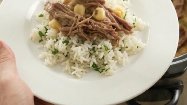 Shredded beef barbacoa with creamy cheddar sauce, hominy, and poblano peppers in a slow cooker