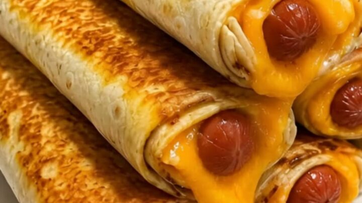 A stack of crispy golden-brown hot dog cheddar wraps on a white plate with melted cheese oozing out.