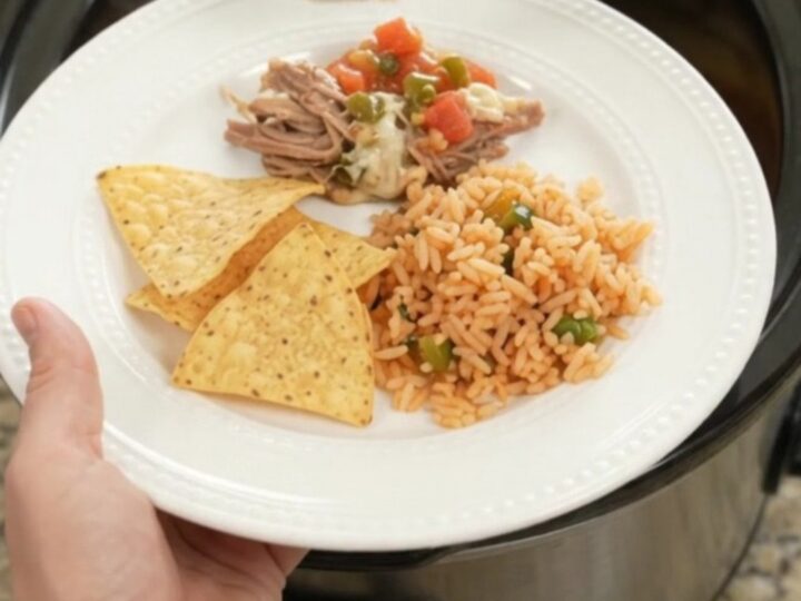 Slow cooker beef barbacoa with melted cheese and jalapeños in a black crockpot