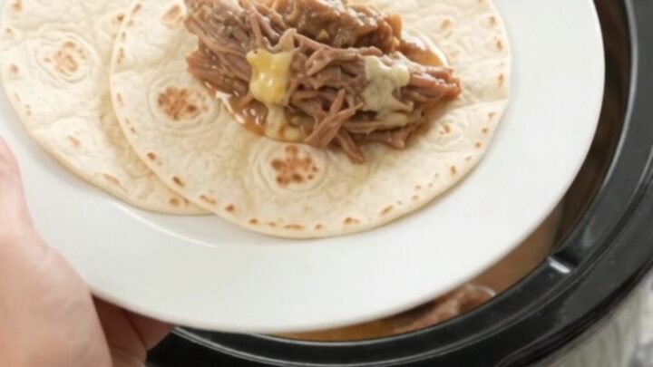 Slow cooker filled with shredded beef barbacoa in creamy mango habanero sauce