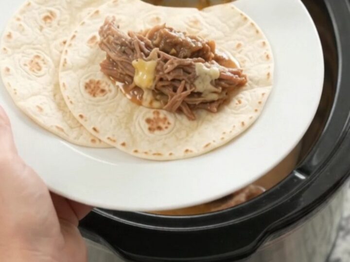 Slow cooker filled with shredded beef barbacoa in creamy mango habanero sauce
