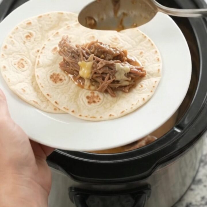 Slow cooker filled with shredded beef barbacoa in creamy mango habanero sauce