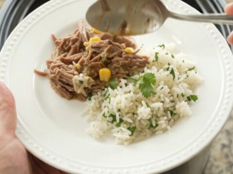 Shredded beef barbacoa in creamy cheese sauce with green chiles and corn in a slow cooker