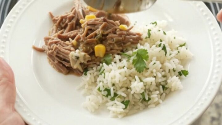 Shredded beef barbacoa in creamy cheese sauce with green chiles and corn in a slow cooker