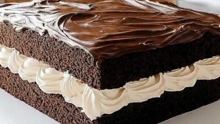 A close-up of a square Ding Dong sheet cake with visible layers of dark chocolate cake and ruffled cream.