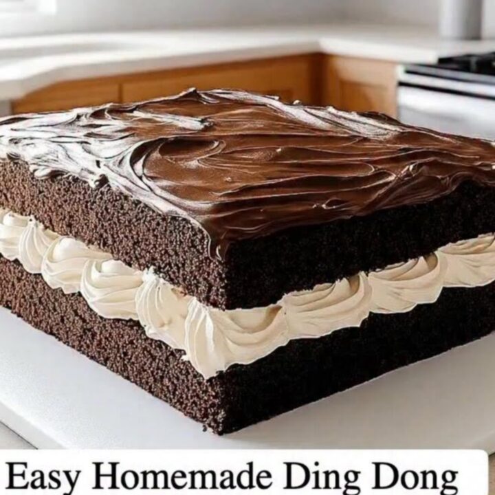 A close-up of a square Ding Dong sheet cake with visible layers of dark chocolate cake and ruffled cream.