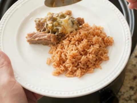 Slow cooker full of cheesy salsa verde pork carnitas, bubbling and steaming