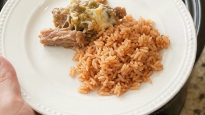 Slow cooker full of cheesy salsa verde pork carnitas, bubbling and steaming