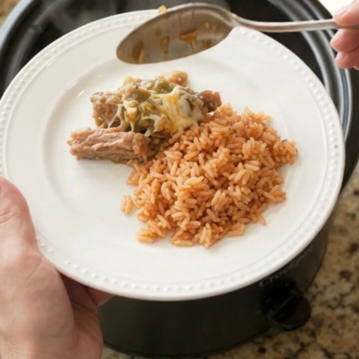 Slow cooker full of cheesy salsa verde pork carnitas, bubbling and steaming