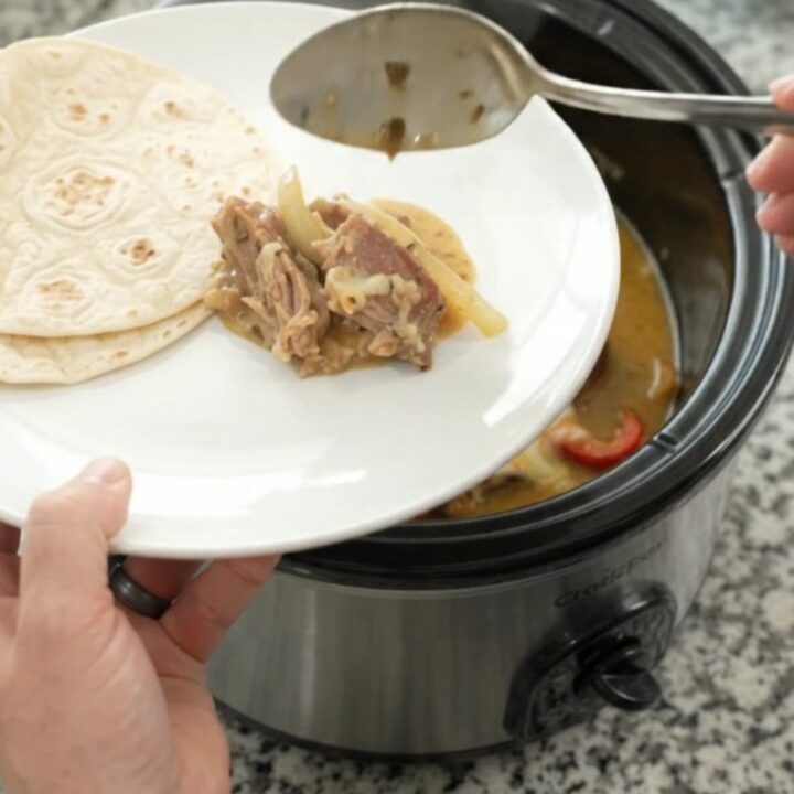 Slow-cooker fajita pork carnitas with creamy Monterey Jack sauce in a black crockpot