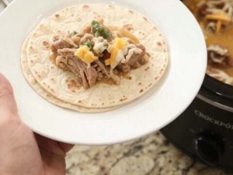 Slow cooker pork carnitas in creamy chipotle pineapple sauce, topped with melted cheese