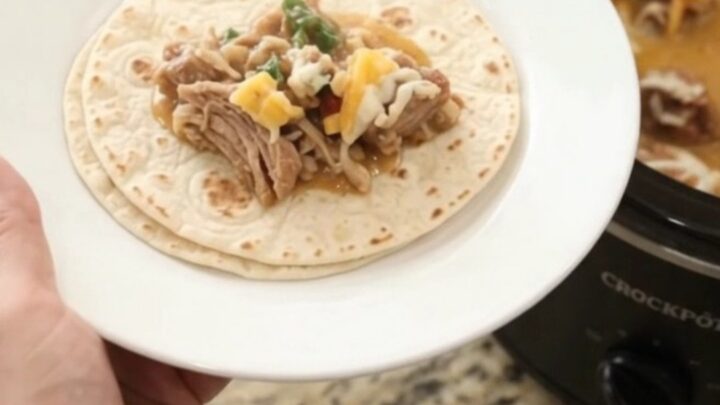 Slow cooker pork carnitas in creamy chipotle pineapple sauce, topped with melted cheese