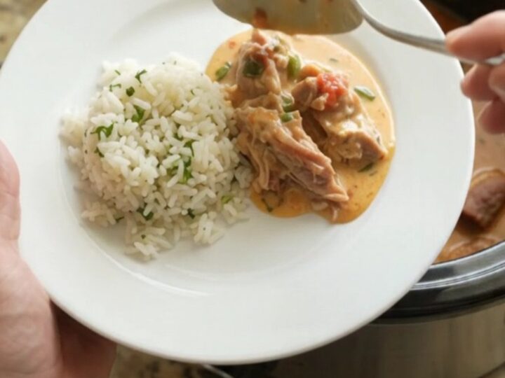 Slow cooker filled with creamy pork carnitas, topped with melted cheddar and jalapeños.