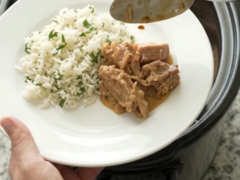 Crockpot full of creamy cheddar taco pork carnitas with pinto beans and melted cheese sauce