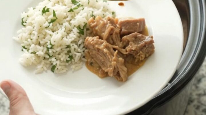 Crockpot full of creamy cheddar taco pork carnitas with pinto beans and melted cheese sauce