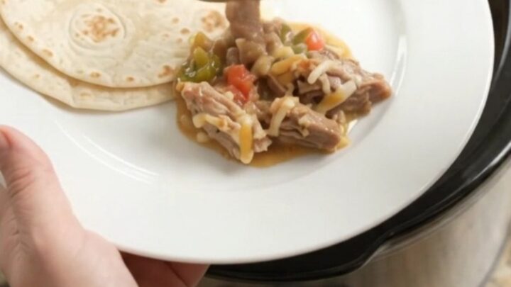 Slow cooker pork carnitas with creamy tomato-jalapeño sauce and melted Monterey Jack cheese.