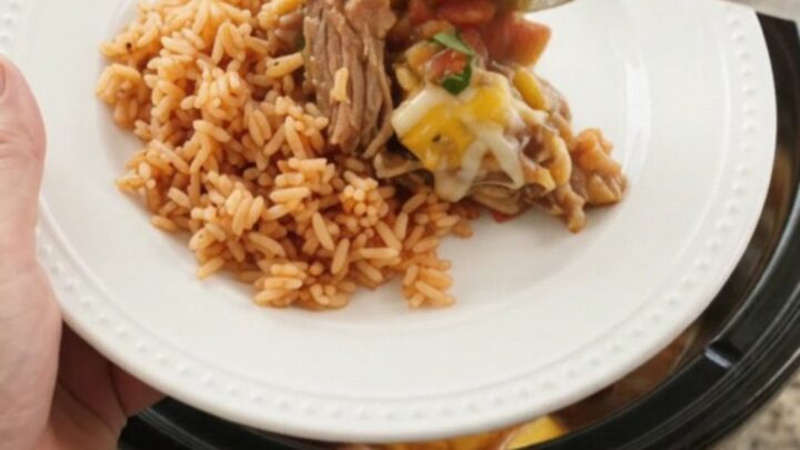 Slow cooker filled with bubbling mango habanero pork carnitas topped with melted cheese