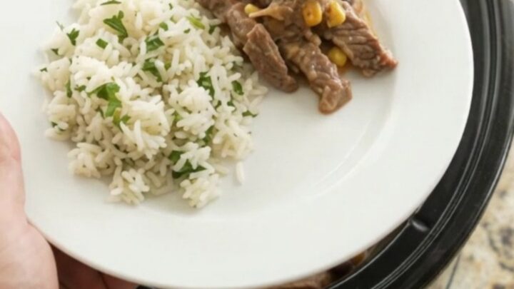 A slow cooker filled with tender skirt steak, black beans, and corn in a creamy cheddar sauce.
