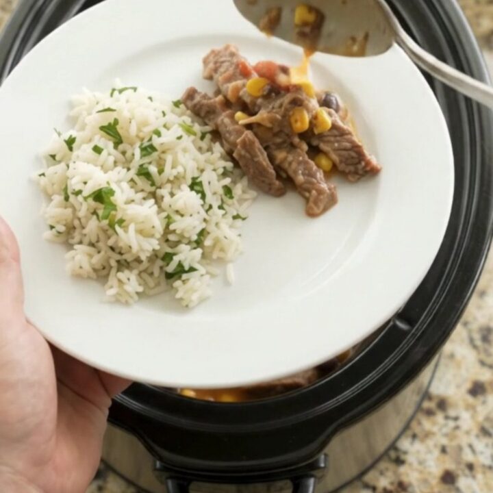 A slow cooker filled with tender skirt steak, black beans, and corn in a creamy cheddar sauce.
