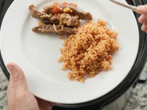 Slow cooker filled with bubbling cheese-topped steak and beans
