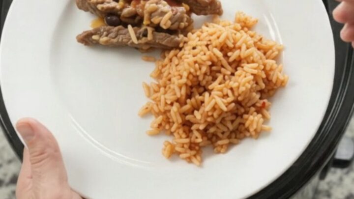 Slow cooker filled with bubbling cheese-topped steak and beans