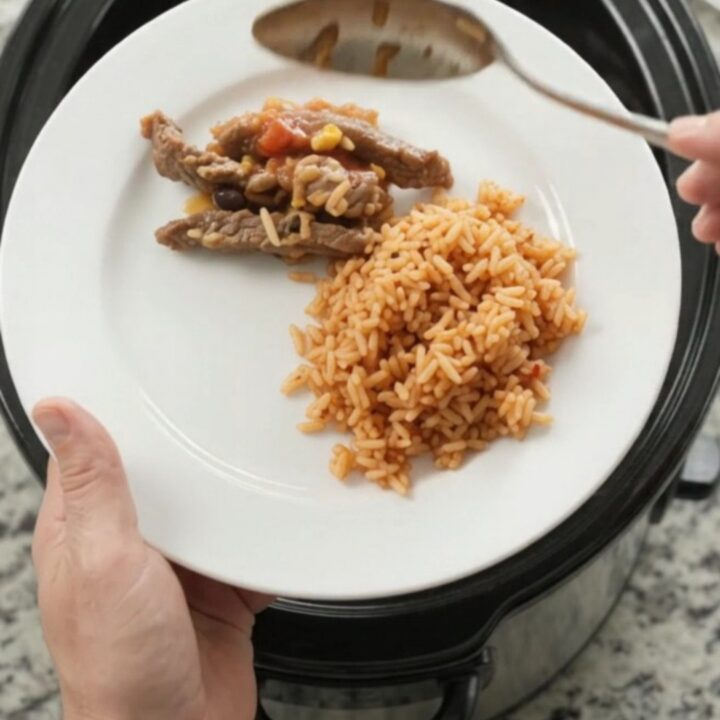 Slow cooker filled with bubbling cheese-topped steak and beans