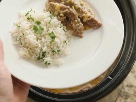 Crockpot with bubbling cheddar salsa verde sauce and tender skirt steak strips