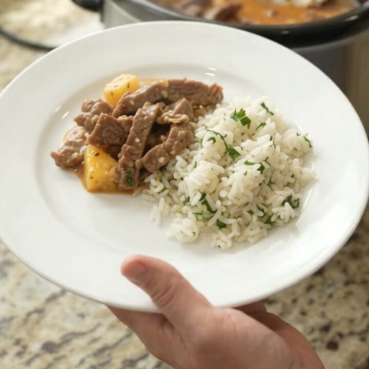 Slow cooker filled with creamy cheddar chipotle pineapple skirt steak, bubbling and steaming