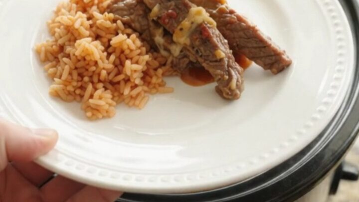 Slow cooker filled with tender skirt steak strips in a chipotle pineapple sauce, topped with melted Oaxaca cheese.