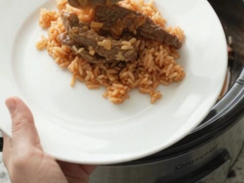 A slow cooker filled with tender skirt steak, roasted poblanos, and hominy in a melted Oaxaca cheese sauce.