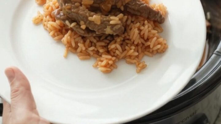 A slow cooker filled with tender skirt steak, roasted poblanos, and hominy in a melted Oaxaca cheese sauce.