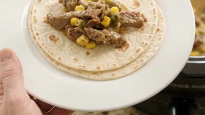 Slow cooker filled with creamy Monterey Jack sauce, tender skirt steak strips, corn, and green chiles.