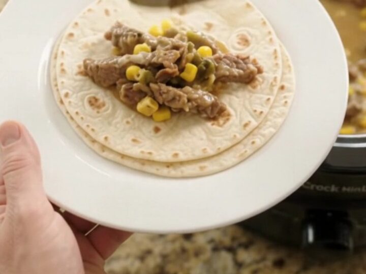 Slow cooker filled with creamy Monterey Jack sauce, tender skirt steak strips, corn, and green chiles.
