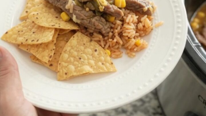 Slow cooker filled with tender skirt steak strips in a creamy pepper jack sauce with green chiles and corn.