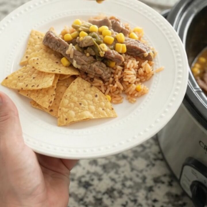 Slow cooker filled with tender skirt steak strips in a creamy pepper jack sauce with green chiles and corn.
