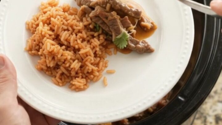 Slow cooker filled with tender skirt steak strips, melted Oaxaca cheese, and mango habanero sauce, bubbling and steaming