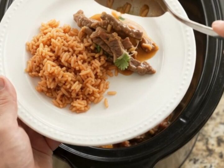 Slow cooker filled with tender skirt steak strips, melted Oaxaca cheese, and mango habanero sauce, bubbling and steaming