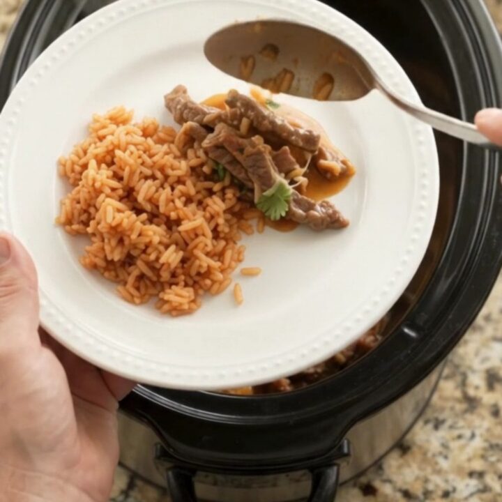 Slow cooker filled with tender skirt steak strips, melted Oaxaca cheese, and mango habanero sauce, bubbling and steaming