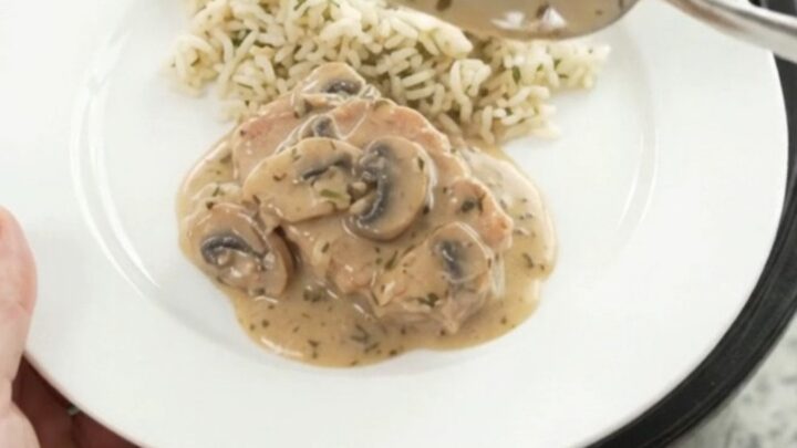 Creamy slow-cooker pork chops with mushroom-ranch sauce in a black Crockpot