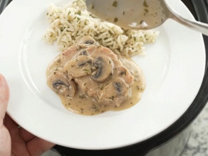 Creamy slow-cooker pork chops with mushroom-ranch sauce in a black Crockpot
