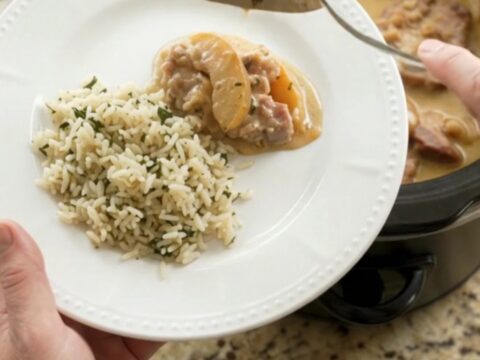 Crockpot with bubbling Parmesan apple cider pork chops and apples