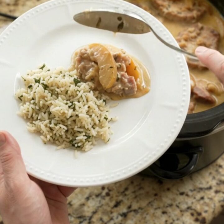 Crockpot with bubbling Parmesan apple cider pork chops and apples