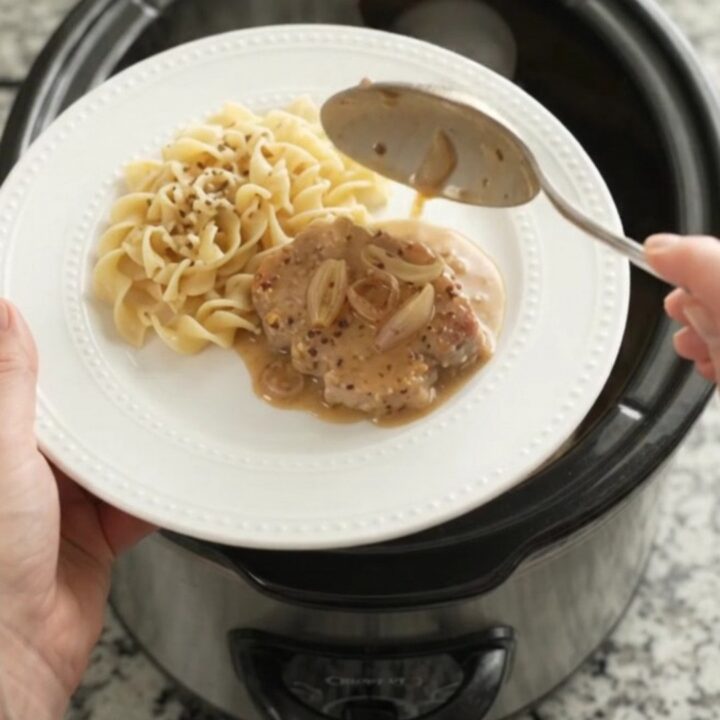 Crockpot Sour Cream Honey Dijon Pork Chops in a slow cooker with creamy sauce