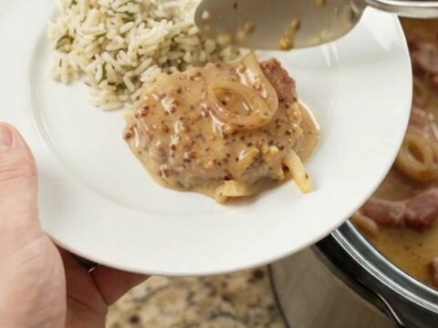 Slow cooker full of Parmesan honey Dijon pork chops in creamy sauce