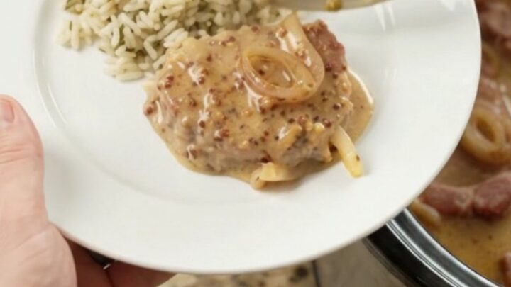 Slow cooker full of Parmesan honey Dijon pork chops in creamy sauce