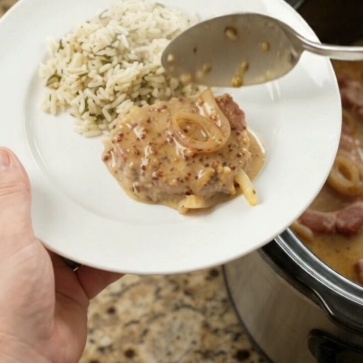 Slow cooker full of Parmesan honey Dijon pork chops in creamy sauce