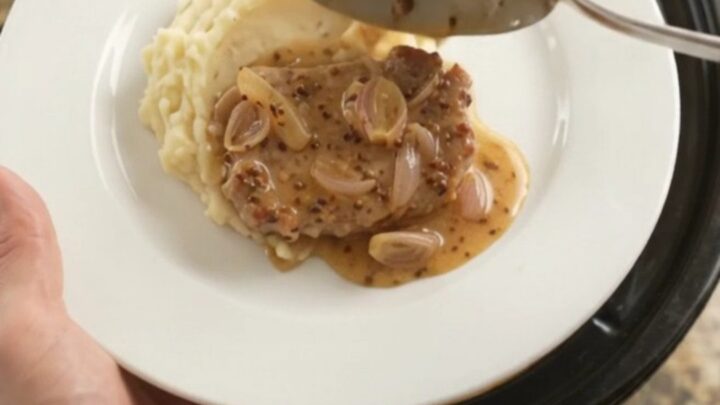 Slow-cooked pork chops in a creamy honey-Dijon sauce with melted Gruyère in a crockpot