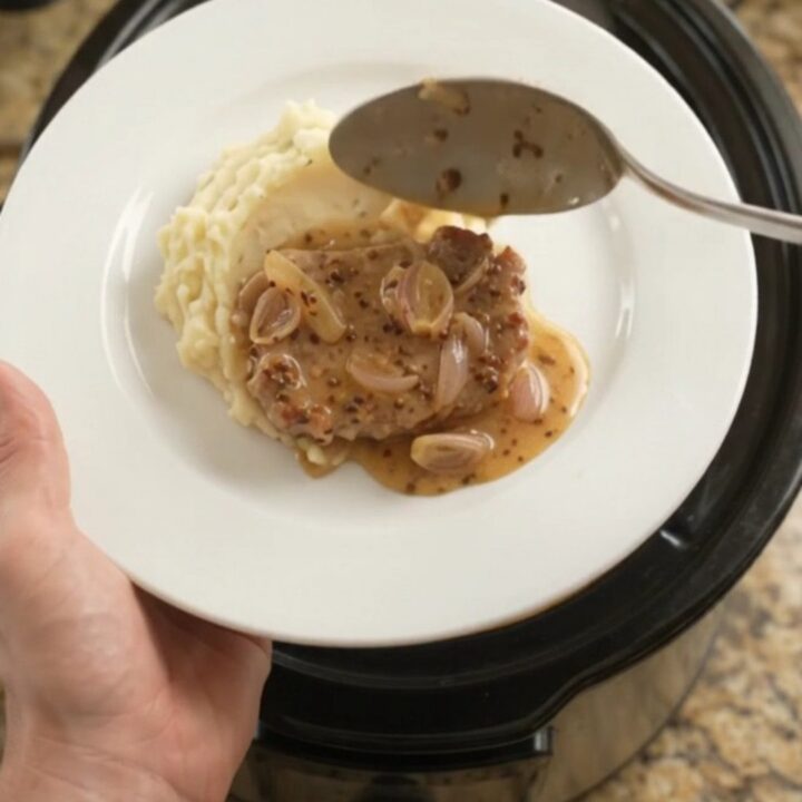Slow-cooked pork chops in a creamy honey-Dijon sauce with melted Gruyère in a crockpot
