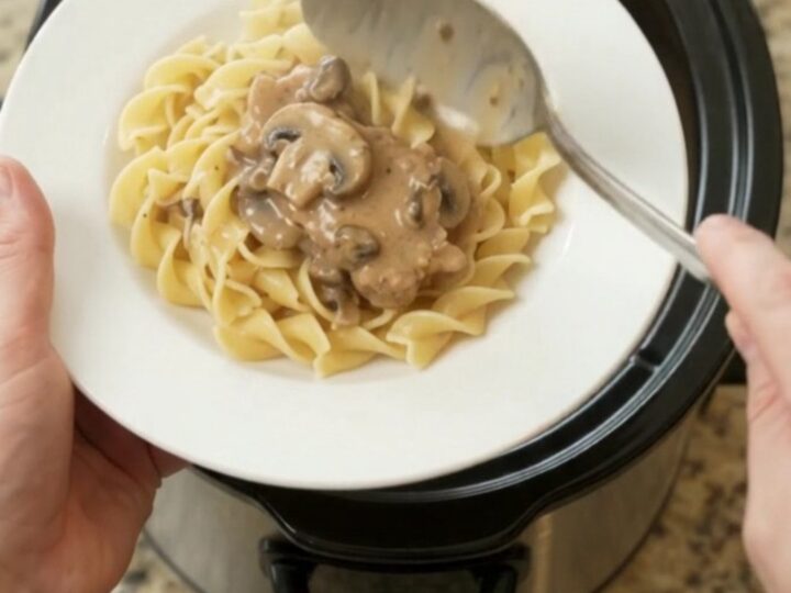 Slow cooker ribeye pork chops in creamy mushroom ranch sauce, topped with a spoonful of gravy.